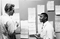 Dental students talking in front of annoucement board, 1965